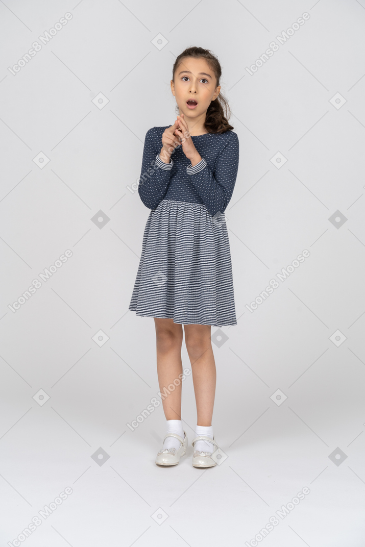 Front view of a girl gasping in shock while fiddling with her fingers