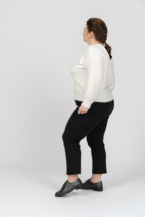 Plus size woman in casual clothes standing in profile