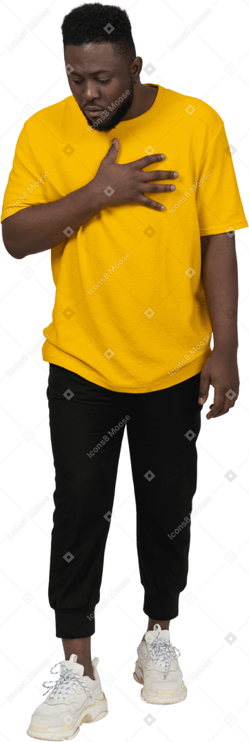 一个穿着黄色 t 恤、摸着胸口的黑皮肤年轻男子惊讶的前视图