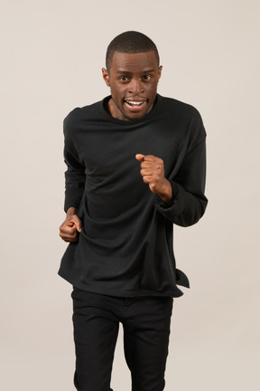 Happy young man running and looking at camera