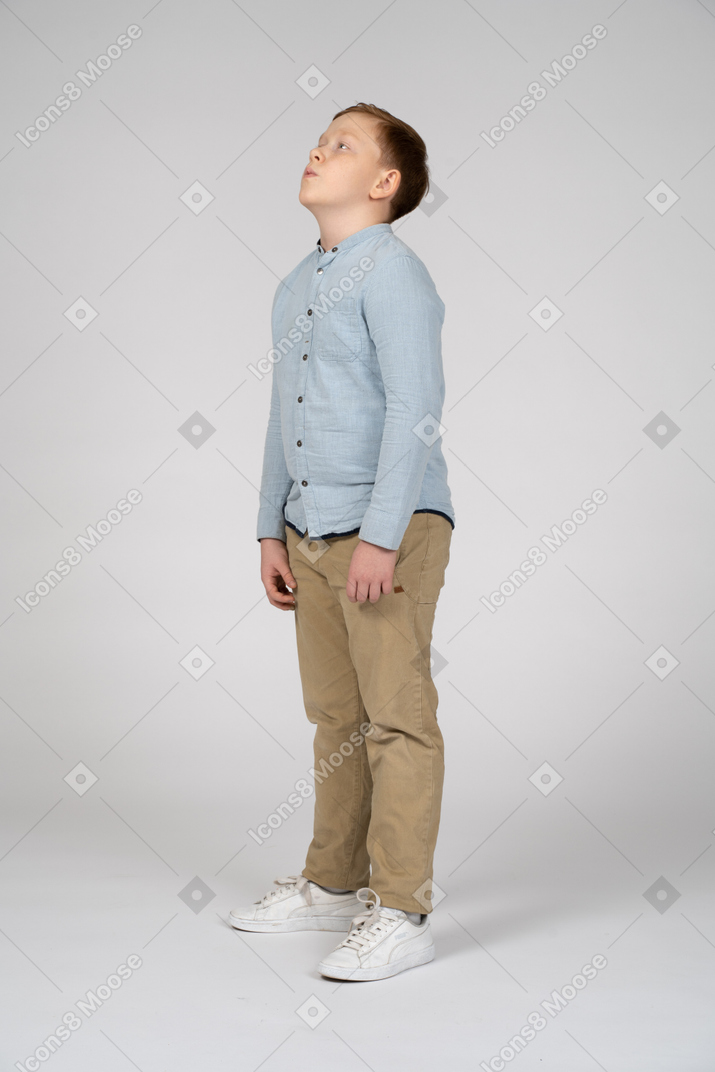 Boy in casual clothes looking up