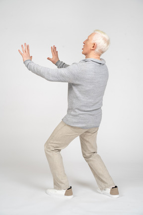 Rear view of man showing stop sign with both hands