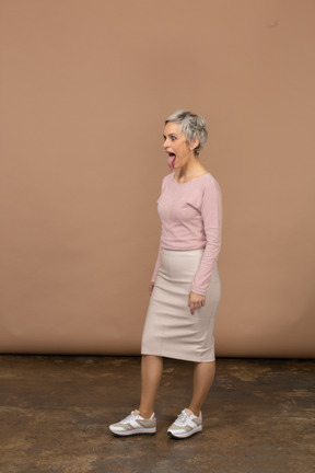 Vue latérale d'une femme en vêtements décontractés montrant la langue