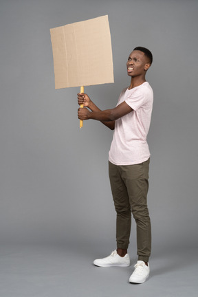 Angry young man with a poster looking sideways