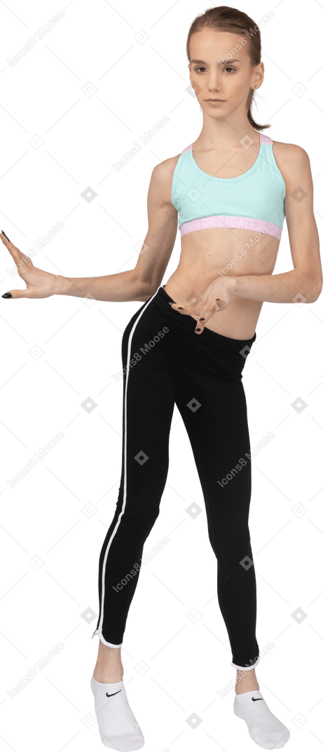 Front view of a teen girl in sportswear dancing while gesticulating