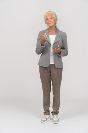 手で指しているスーツの老婦人の正面図