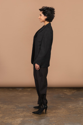 Seitenansicht einer lächelnden geschäftsfrau, die schwarzen anzug trägt
