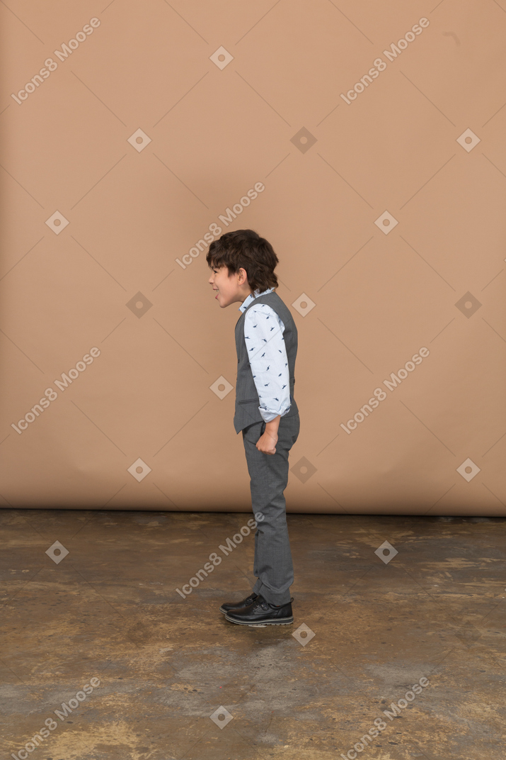 プロファイルに立っているスーツの少年