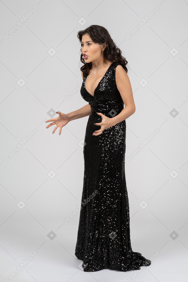 Hermosa mujer enojada en vestido de noche negro listo para destrozar a alguien