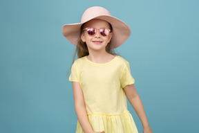 Jolie petite fille portant un chapeau et des lunettes de soleil