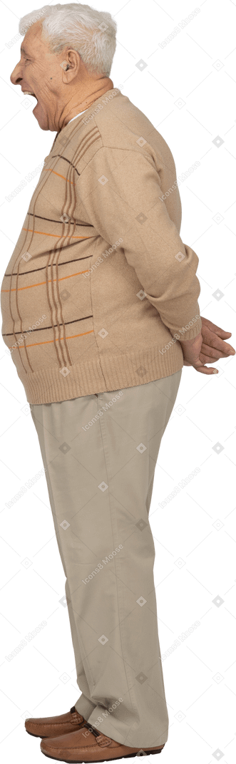 Seitenansicht eines alten mannes in freizeitkleidung, der mit den händen hinter dem rücken steht