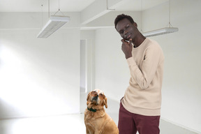 Pensive man standing next to a labrador in sunglasses