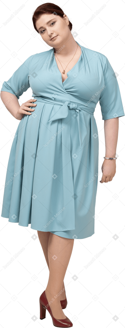 Front view of a woman in blue dress posing with hand on hip