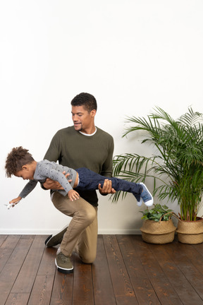 Good looking young man playing with a boy