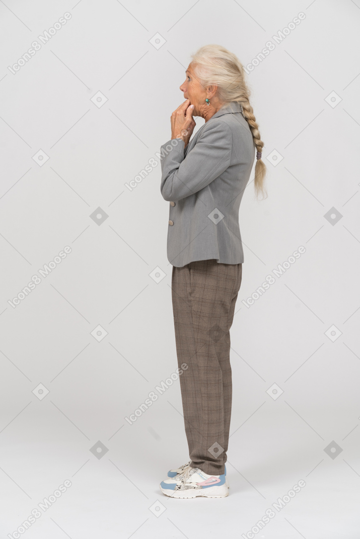 Side view of an old lady in suit whistling