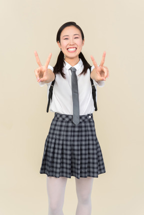 Asian school girl showing victory sign