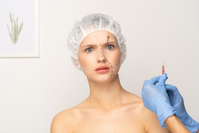 Young woman looking panicked before filler injection