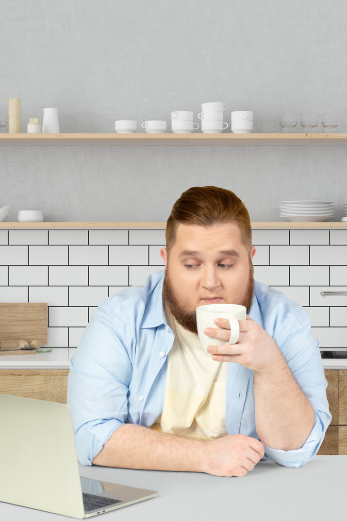 Man sitting at a desk and drinking coffee