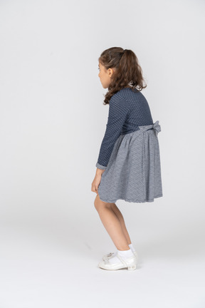 Three-quarter back view of a girl squatting and slouching slightly