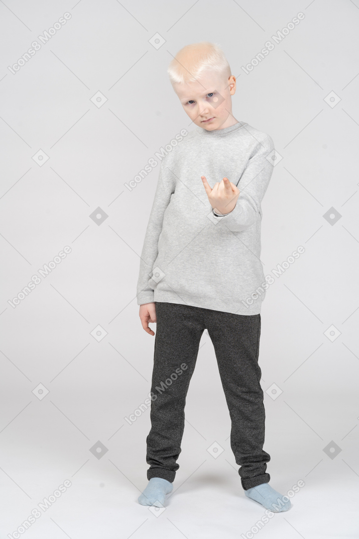 Little boy making rock gesture