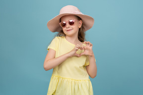 Jolie petite fille portant un chapeau et des lunettes de soleil