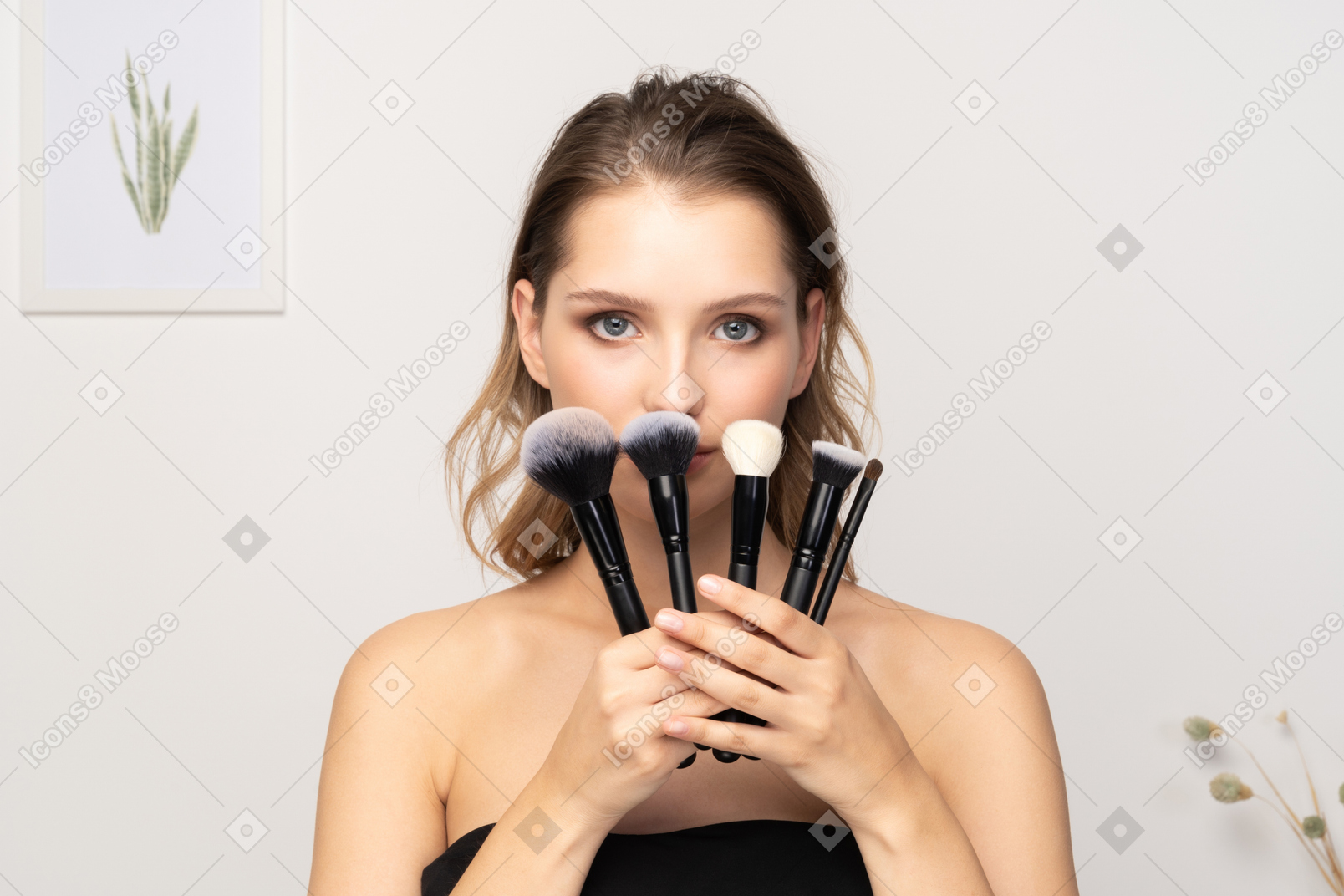 一个性感的年轻女子拿着化妆刷的前视图