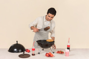 Joven hombre caucásico preparando barbacoa