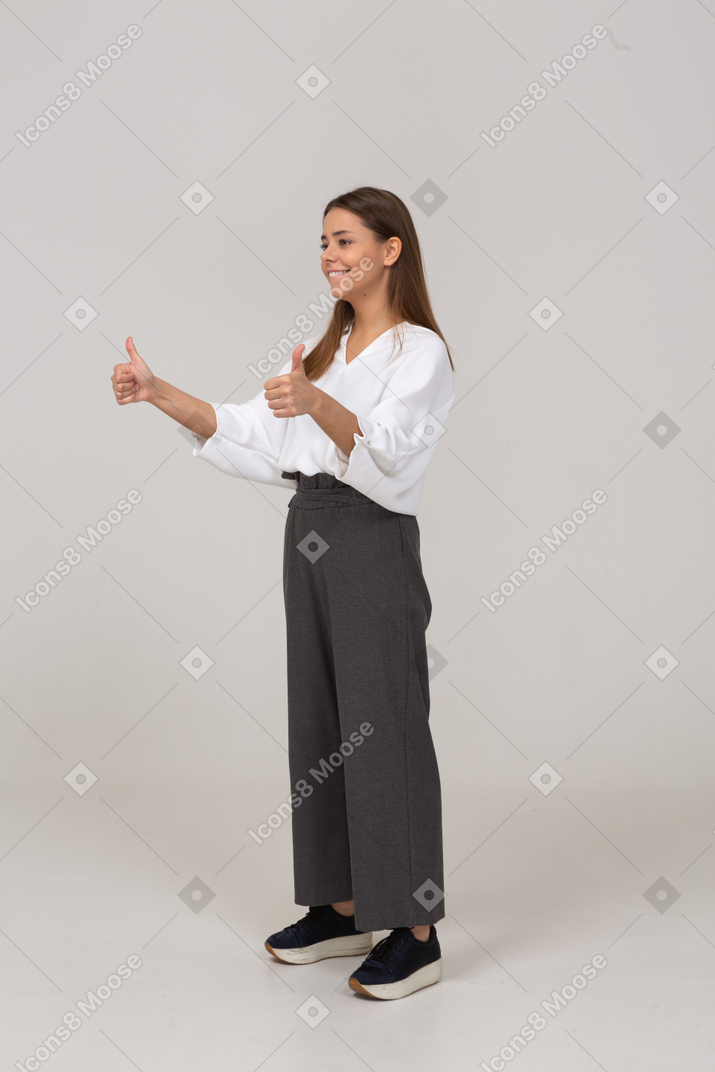 Вид в три четверти молодой леди в офисной одежде, показывающей палец вверх