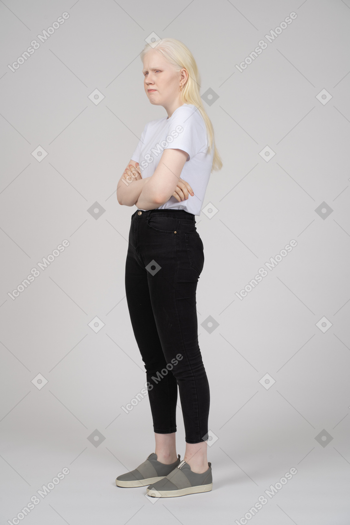 Angry young woman standing with arms crossed