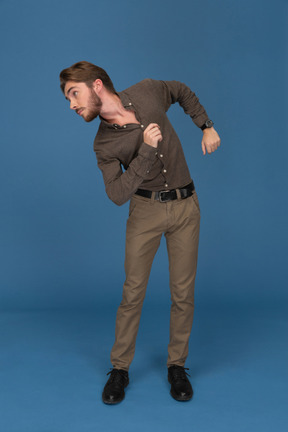 A dancing slim young man looks to camera