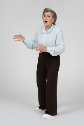 Three-quarter view of an old woman gesturing worriedly