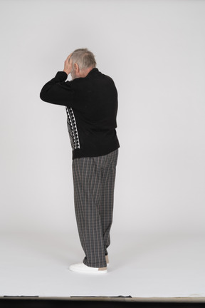 Rear view of old man with hands on head