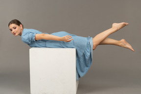 立方体に横たわっている若い女性の側面図