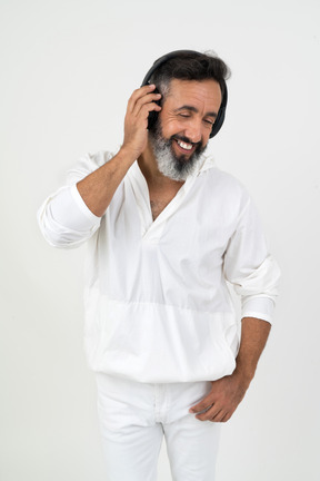 Mature man in headphones smiling while listening to the music