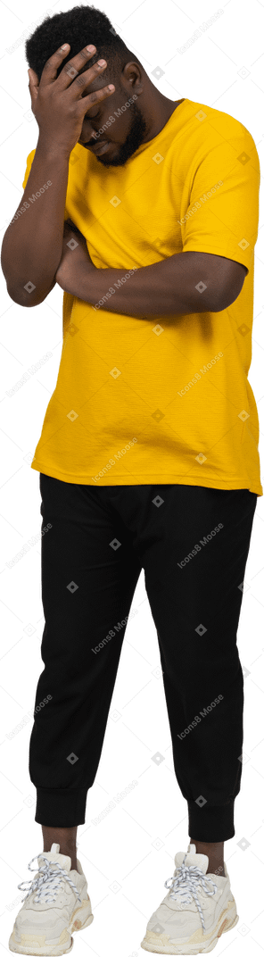 一个羞愧的年轻黑皮肤男子的正面图，黄色 t 恤遮住脸