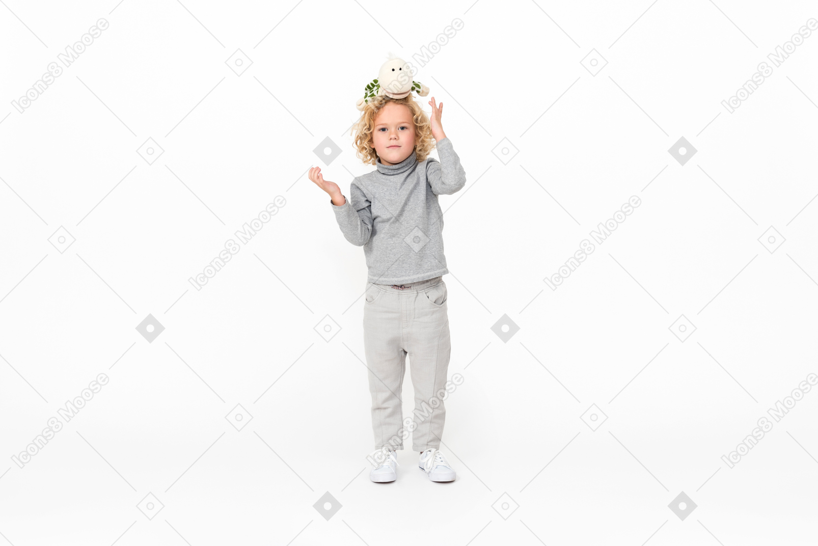 Enfant garçon debout avec des jouets sur la tête