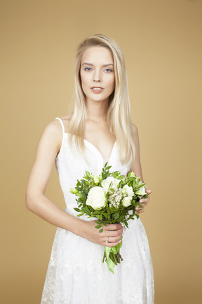 Bella sposa in possesso di un bouquet da sposa di fiori bianchi