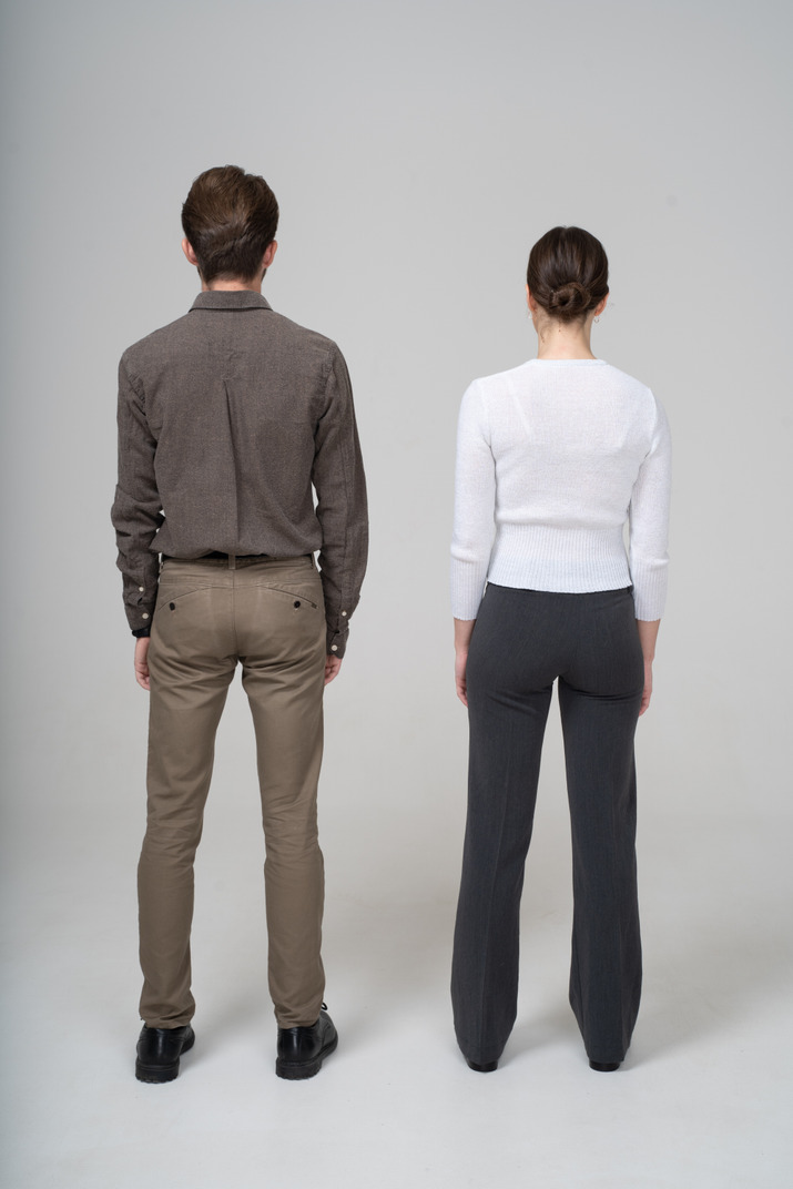 Back view of an unrecognizable young couple in office clothing standing still
