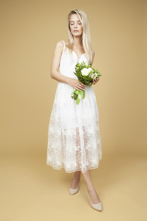 Beauitufl bride holding wedding bouquet and posing for a photo