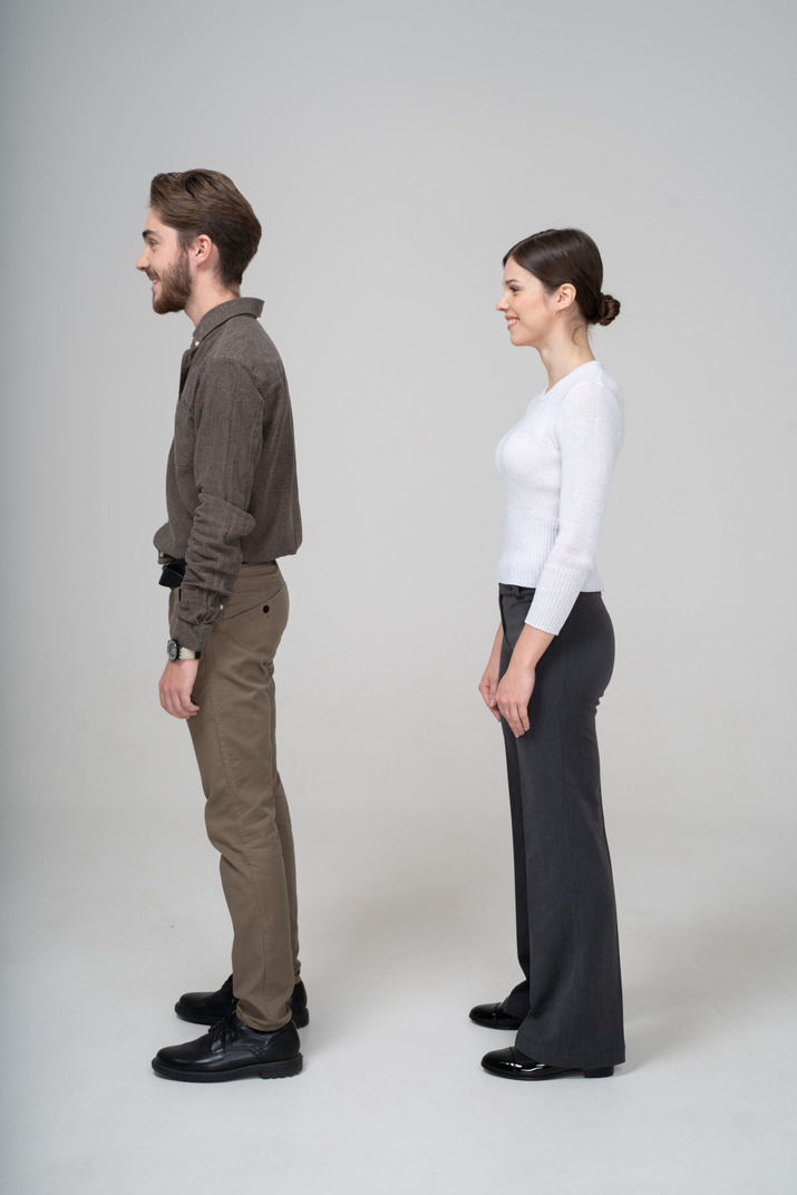 Side view of a smiling young couple in office clothing