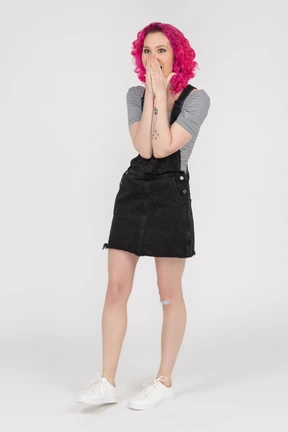 Overwhelmed excited girl covering face with both palms