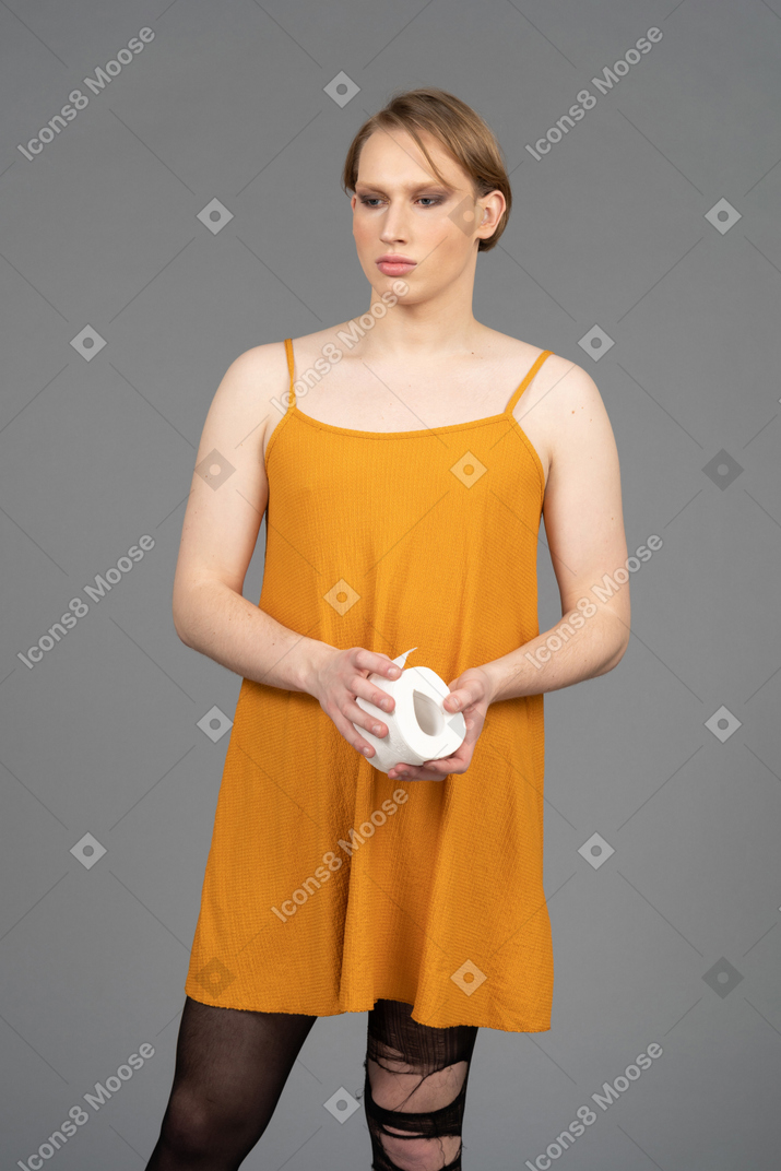 Front view of a genderfluid person holding toilet paper roll
