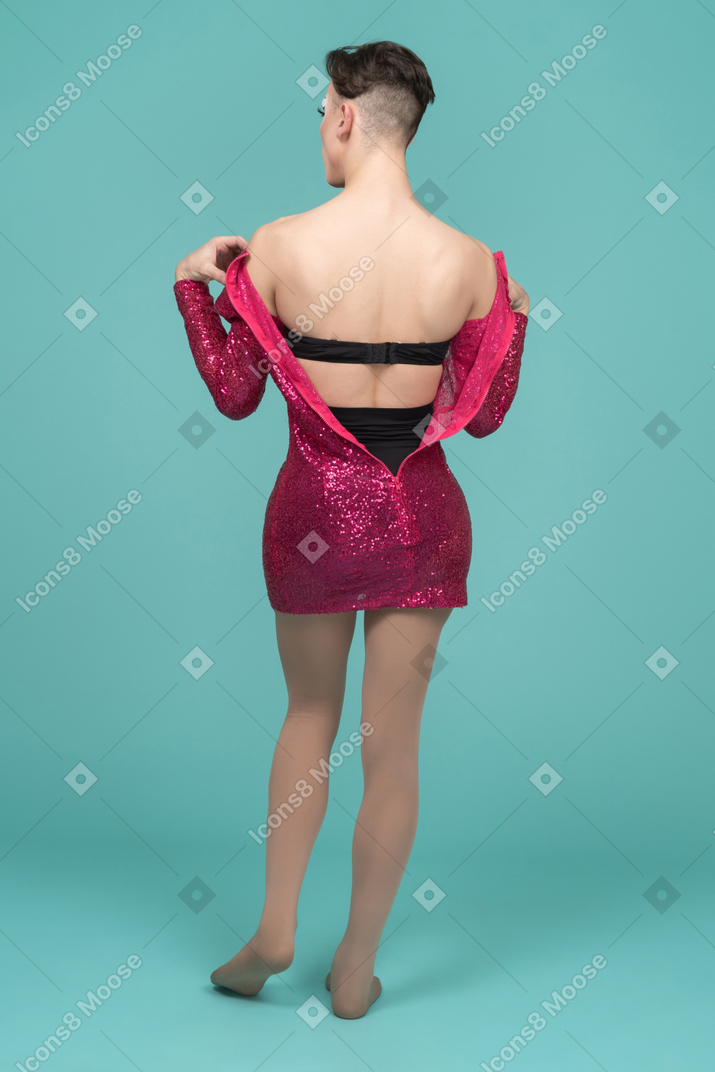 Back view of a drag queen taking off pink dress