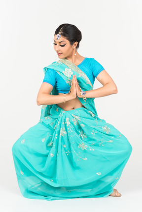 댄스 위치에 서있는 블루 사리에 젊은 인도 여자