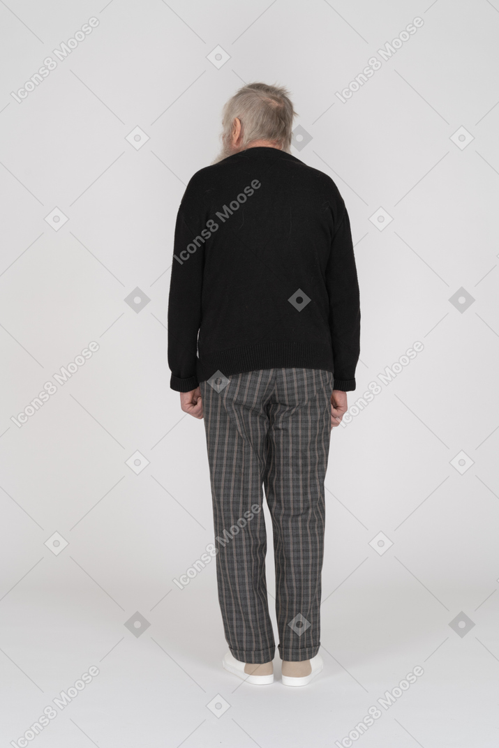 Back view of an old man standing and looking aside