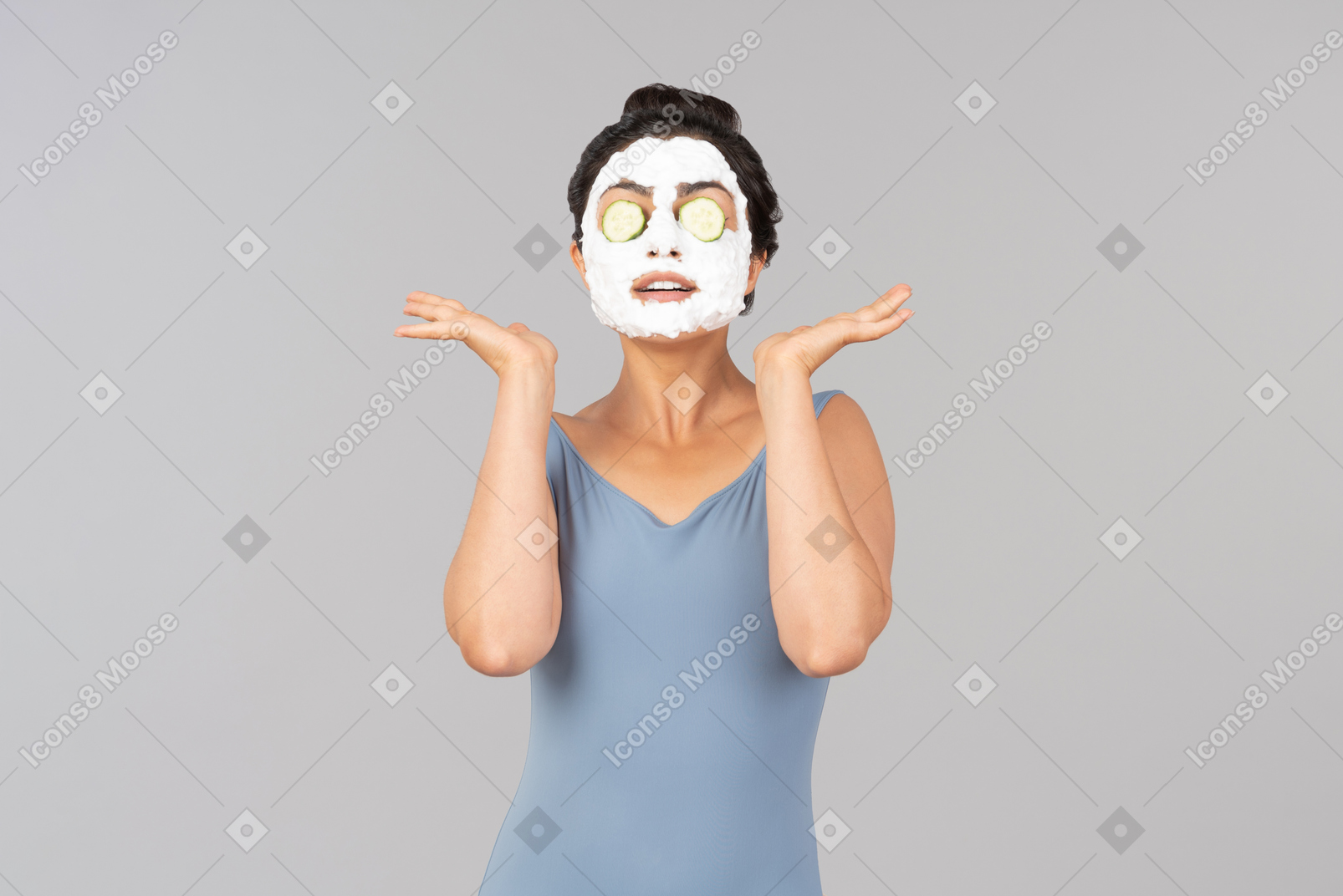 Woman with white facial mask and cucumber slices