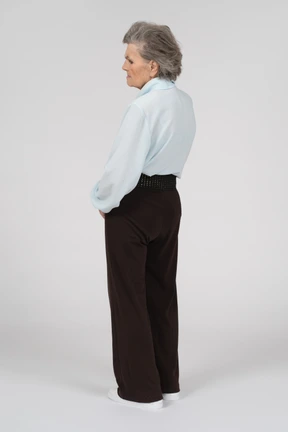 Three-quarter back view of an old woman looking sad and concerned