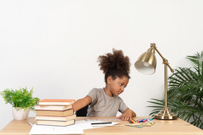 Niña aburrida haciendo su tarea mientras está aislada