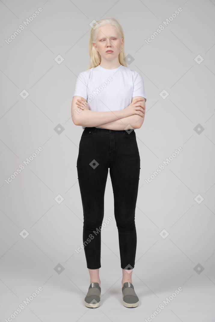 Vista frontale di una giovane donna in piedi con le braccia conserte