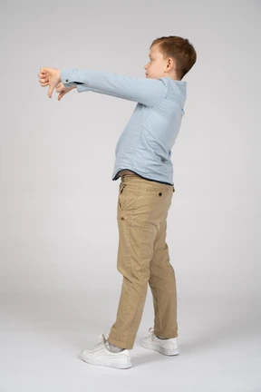 Side view of a boy showing thumbs down